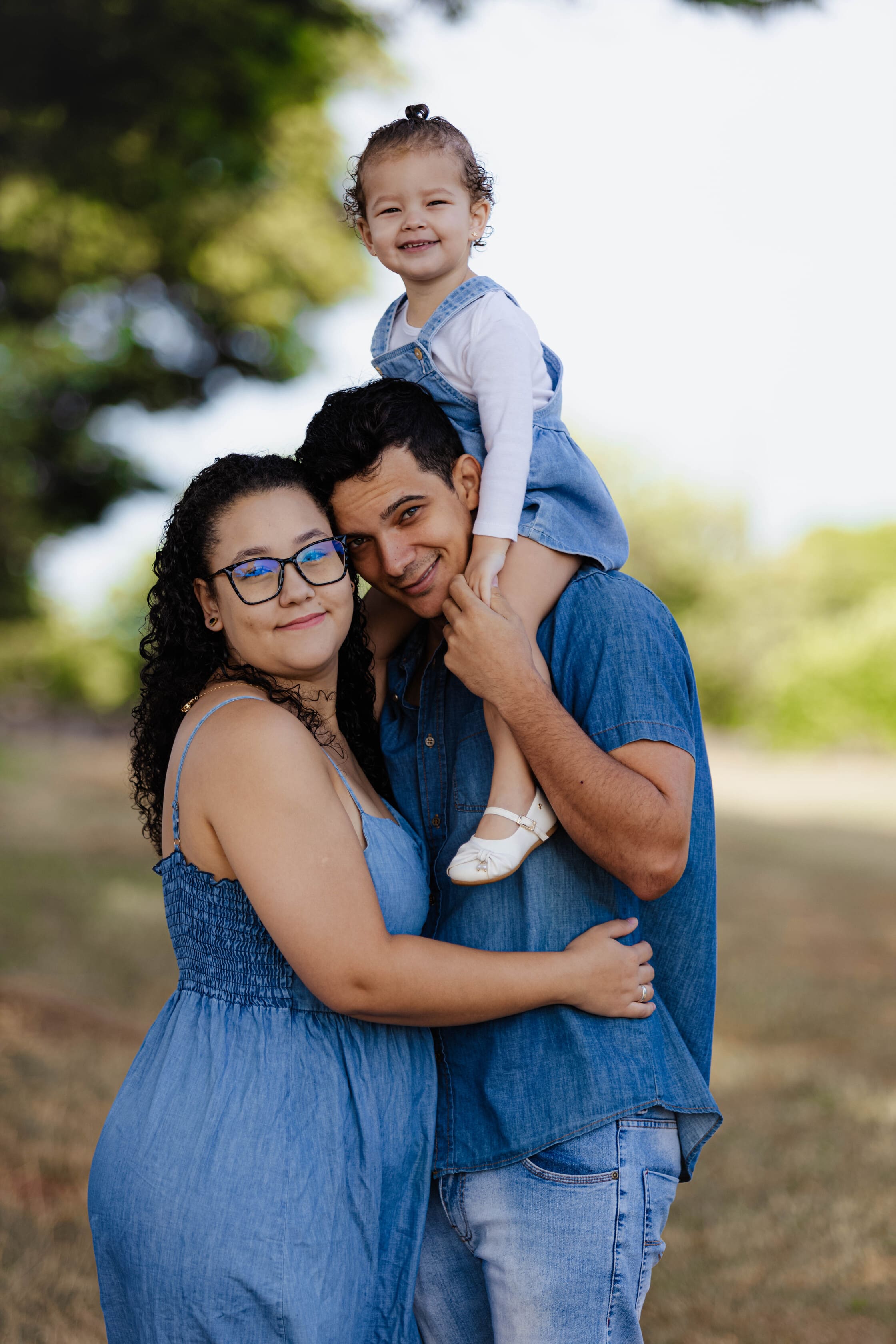 Flavia, Alan e Laura Maria sorrindo juntos durante o ensaio de família em Terra Boa