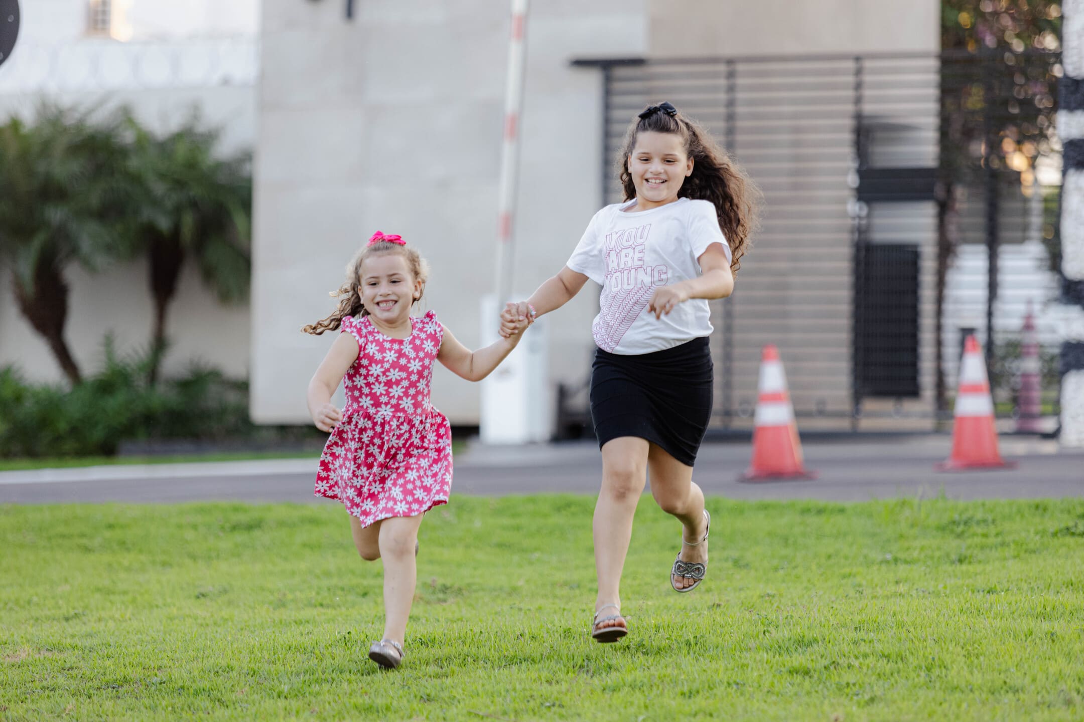 Irmãs Gabrielly e Lorena correndo de mãos dadas no gramado do Residencial Ipanema em Cianorte