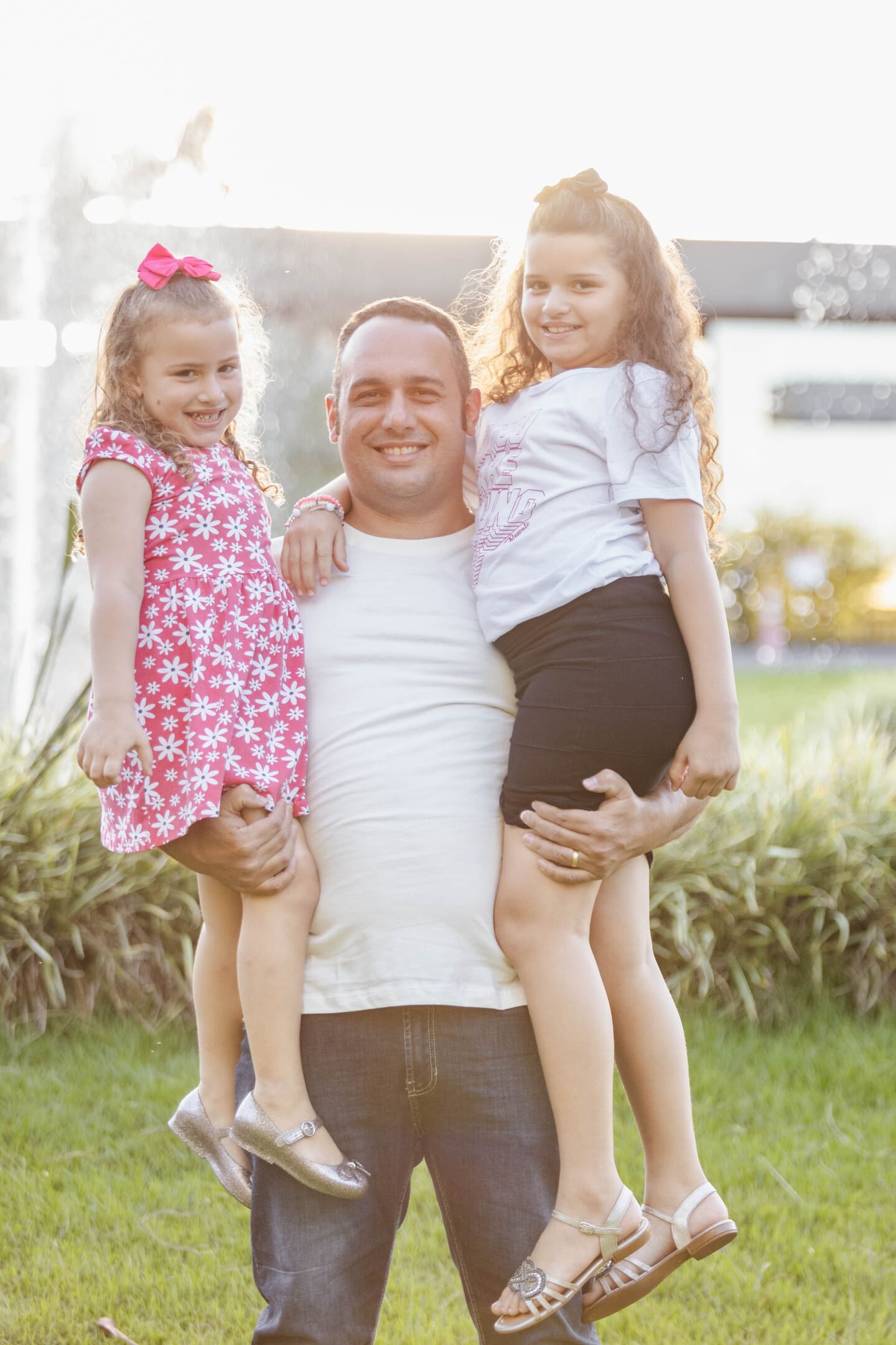 Bruno segurando as filhas Gabrielly e Lorena no colo durante ensaio de família no Residencial Ipanema Cianorte