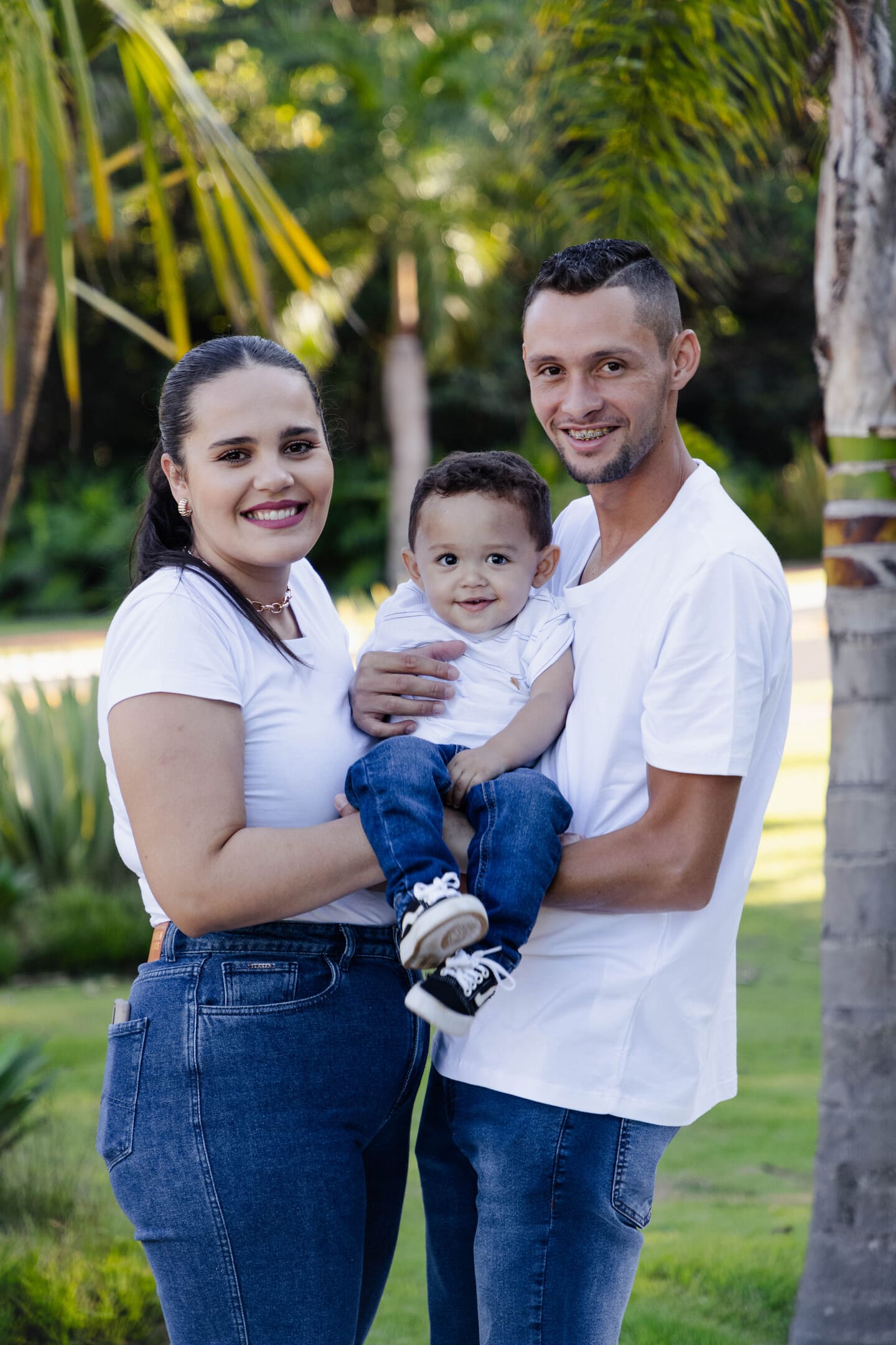Géssica e Willian com Théo no colo entre as palmeiras do Forest Hill em Cianorte