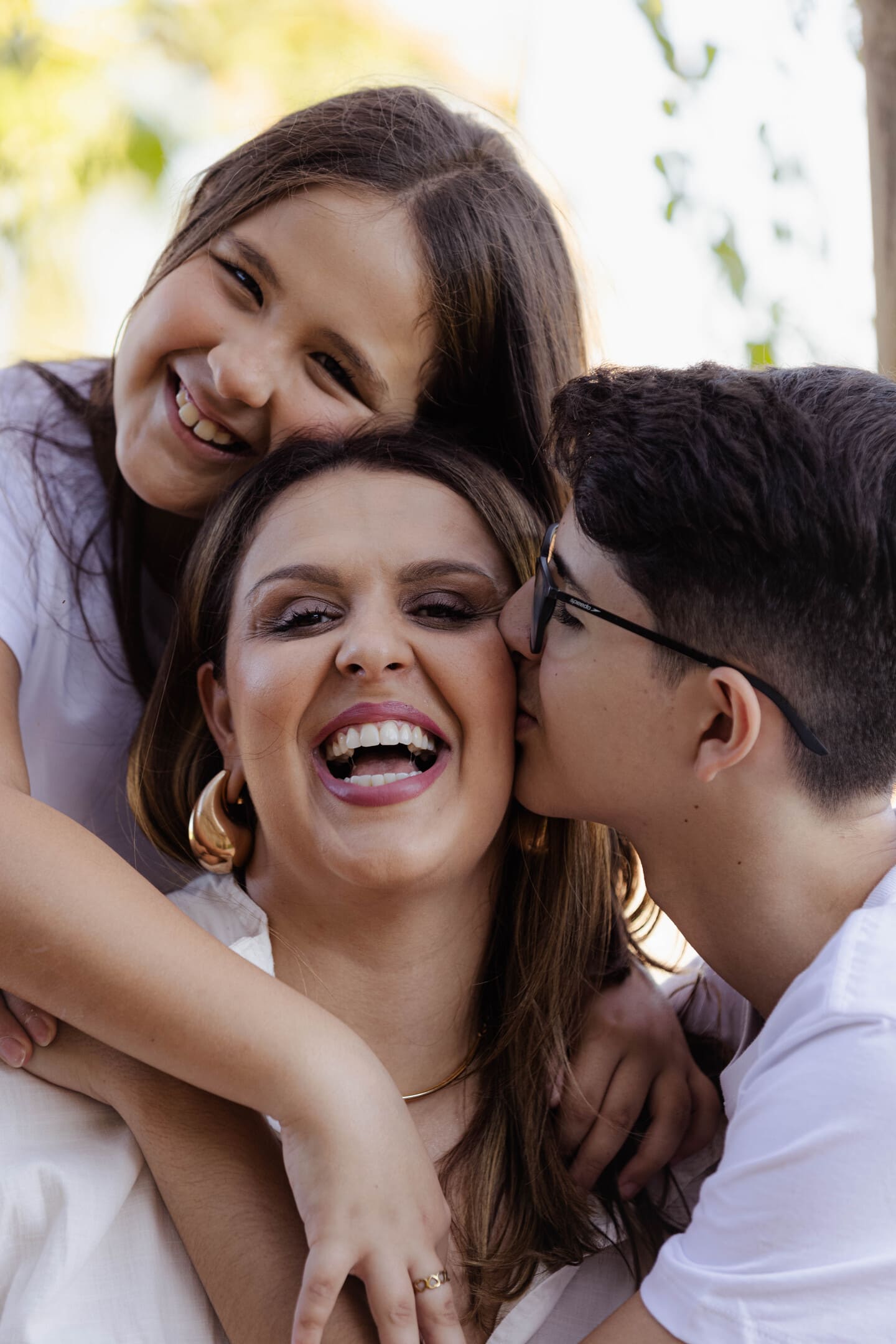 Meire deitada no gramado com Vinícius e Maria Fernanda sorrindo no Condomínio Forest Hill
