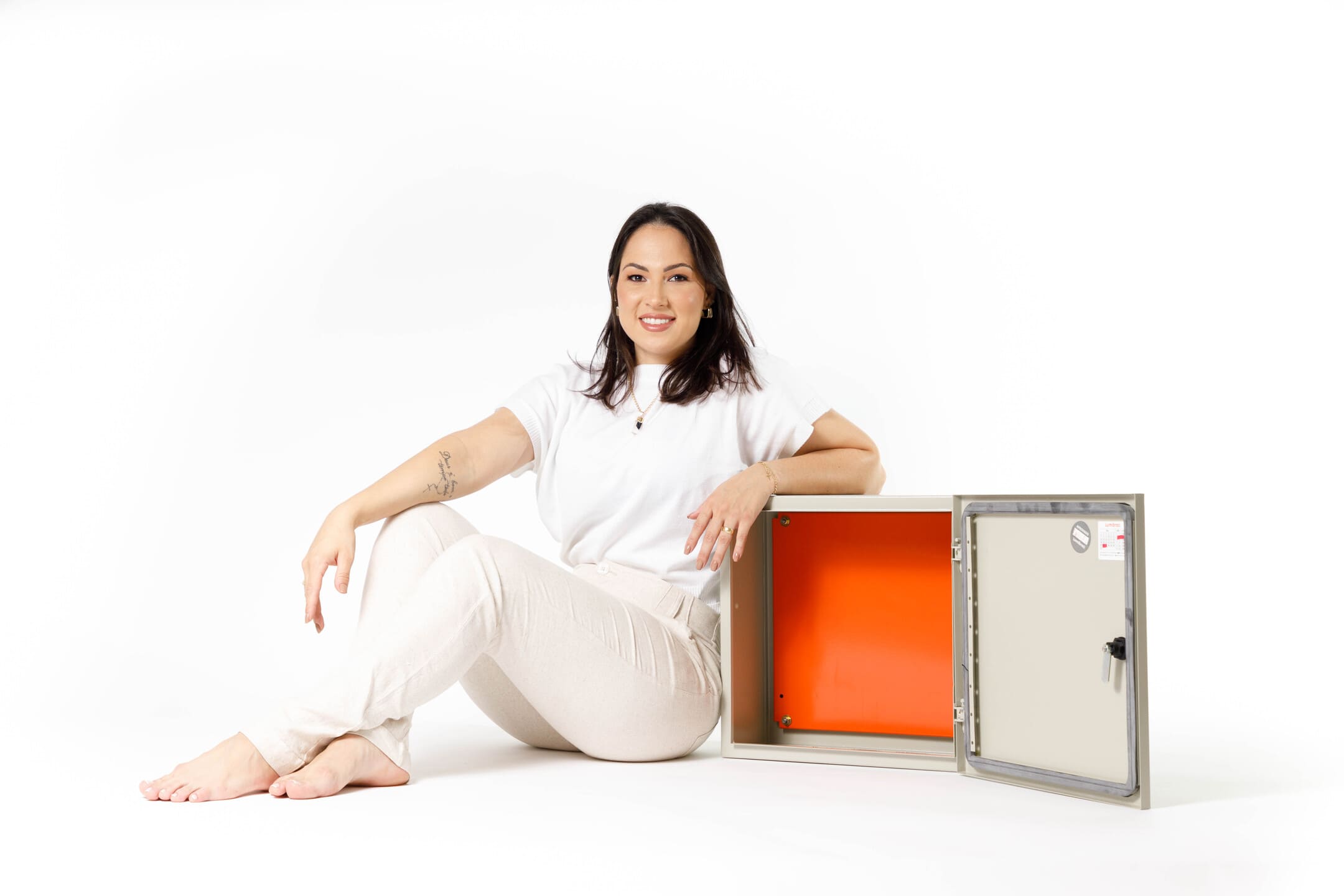 Bruna Umbelino posando ao lado de painel elétrico industrial no Estúdio Foco em Cianorte