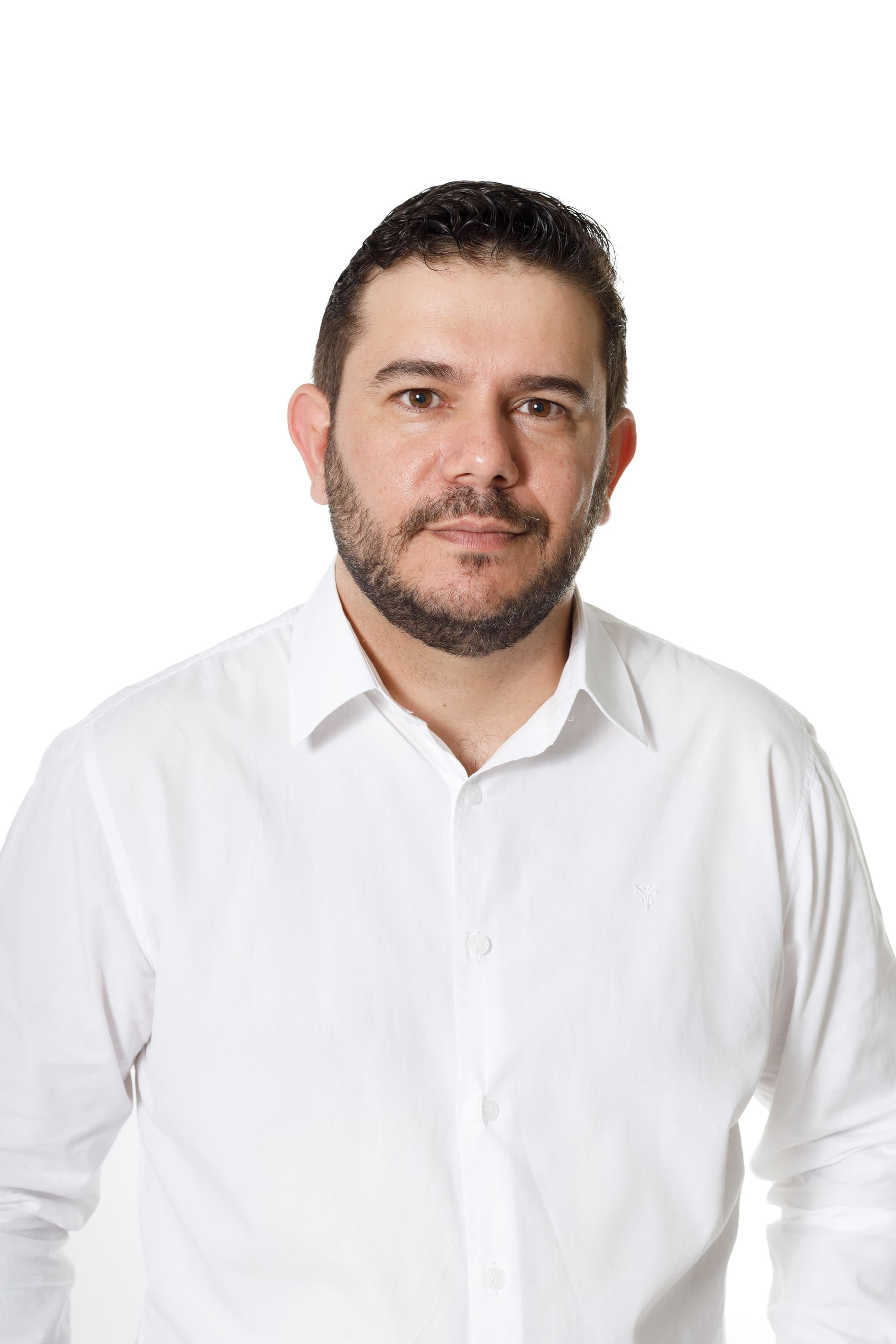 Vereador Rodrigo Rezende sentado em banco de madeira no estúdio de fundo infinito em Cianorte, postura relaxada e profissional