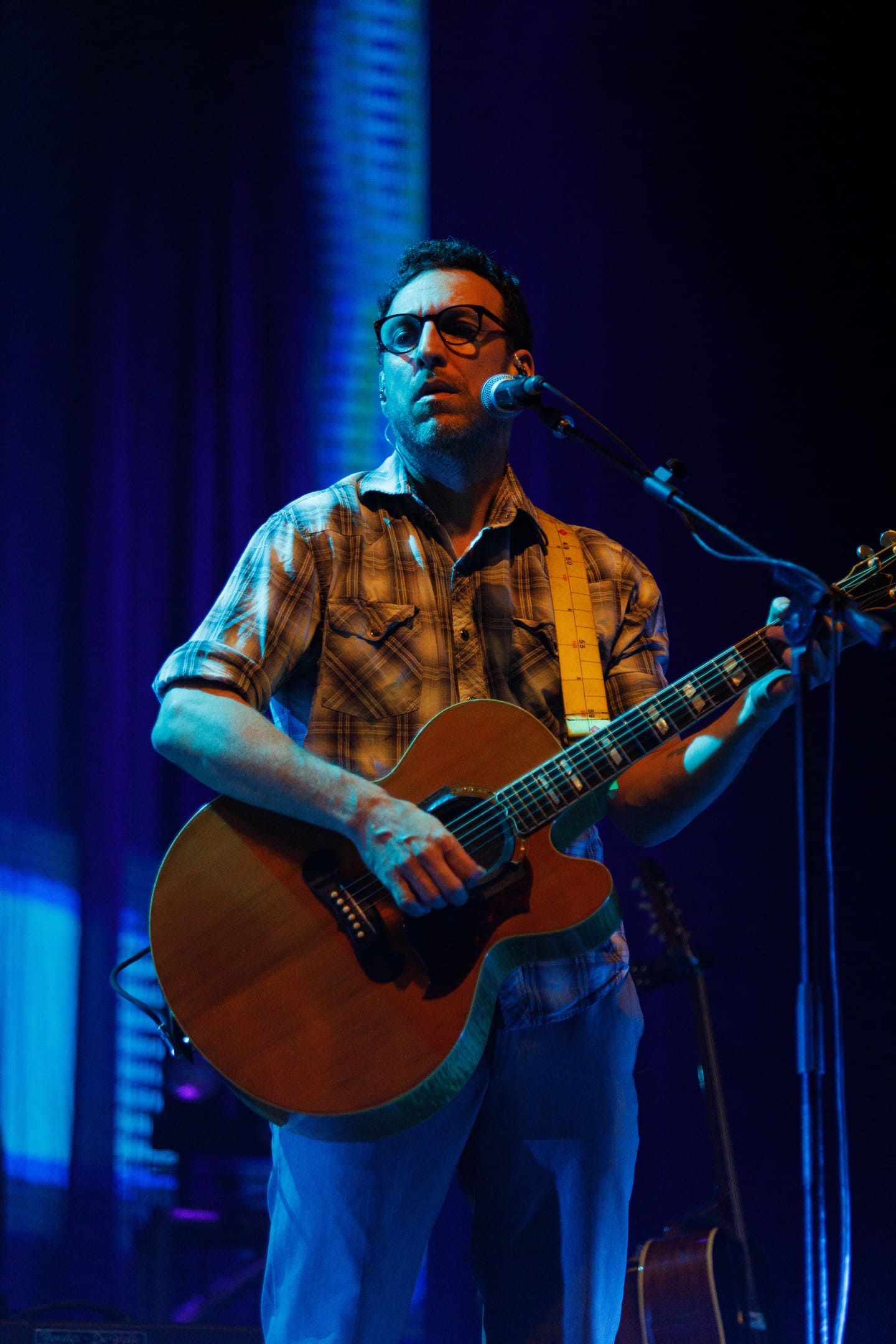 Músico tocando violão acústico no show As V Estações de Dado Villa-Lobos e Marcelo Bonfá